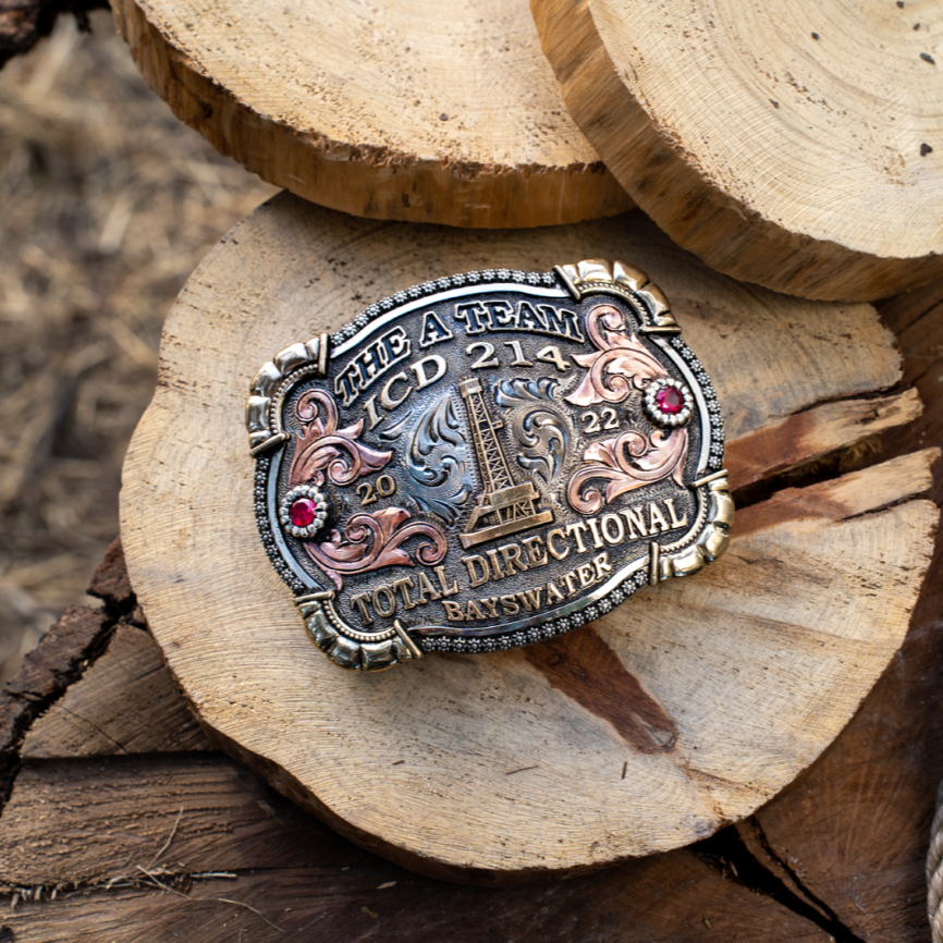 An oil rig western belt buckle on logs 